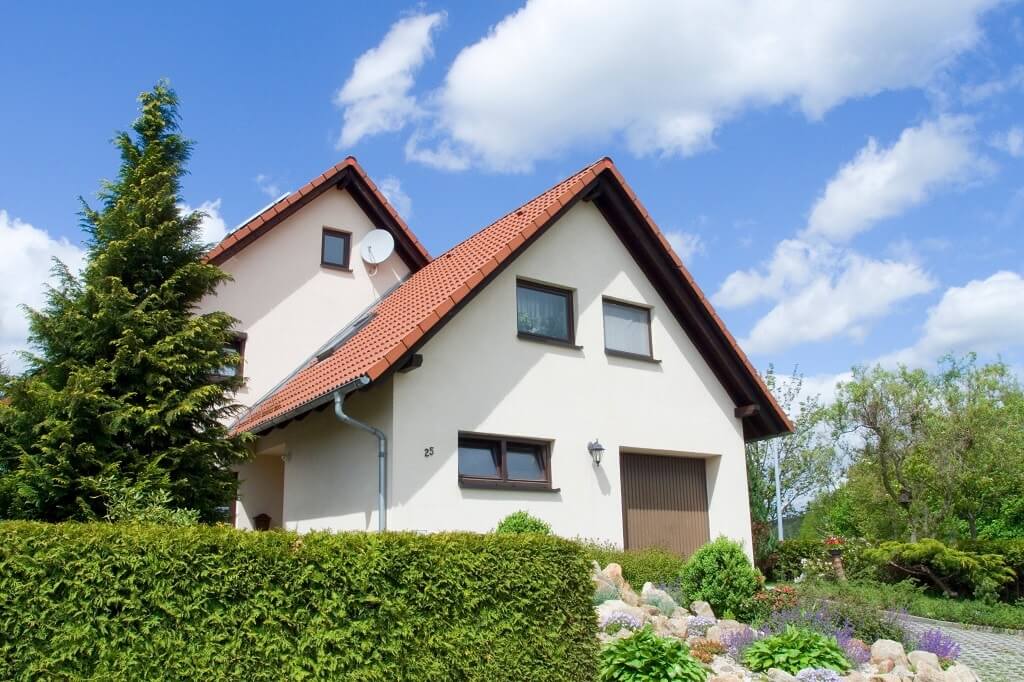 Einfamilienhaus und Vorgarten mit Hecke